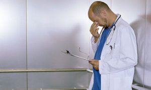 Doctor contemplating The Most Dangerous Myths About Insurance Coverage.